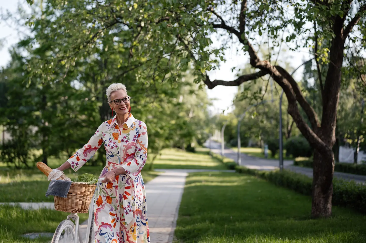 Active senior woman walking with a bicycle, representing everyday movement with knee arthritis
