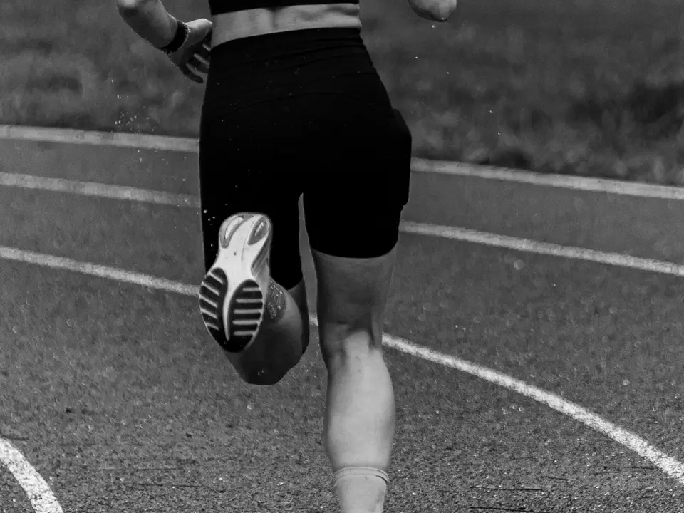 Runner training on a track to represent ACL and sports knee injury care