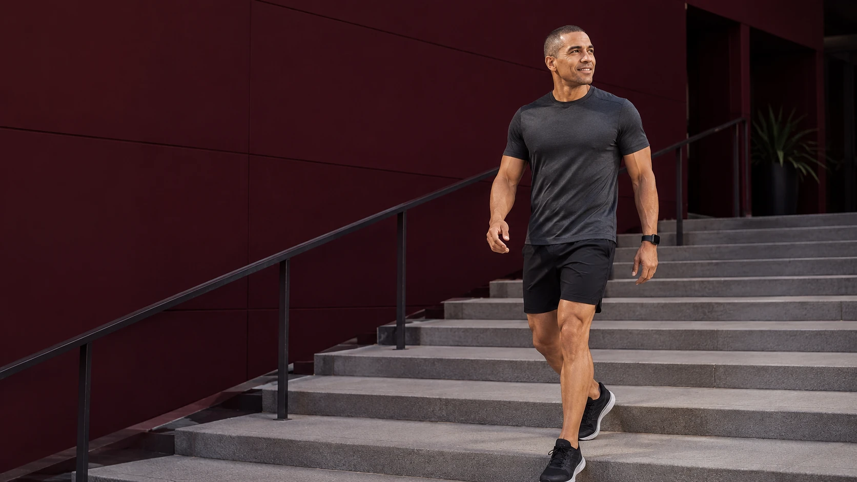 Active man confidently walking down modern stairs after recovery from kneecap pain